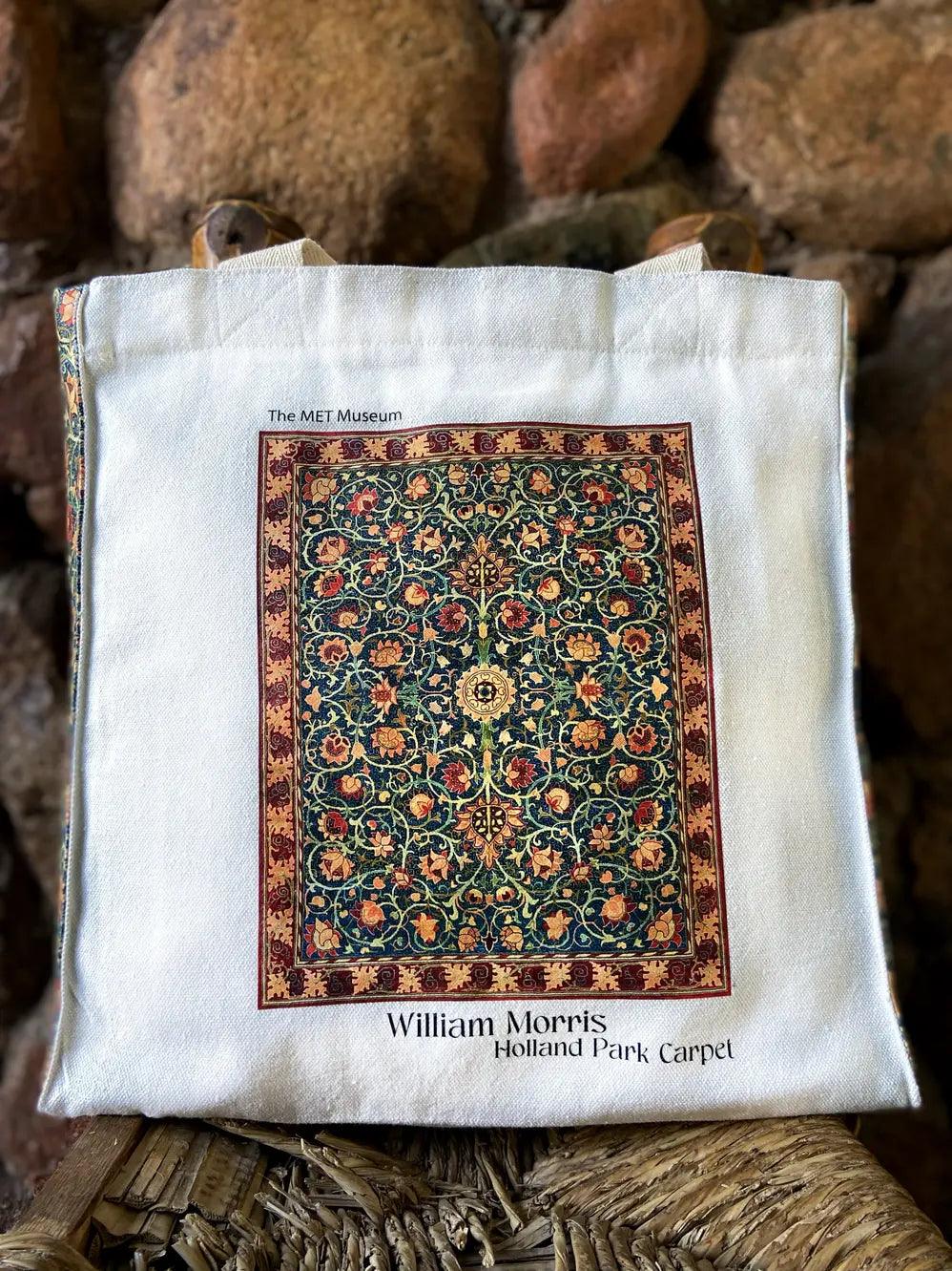 White tote bag with a design of a William Morris Holland Park Carpet on a wooden surface.
